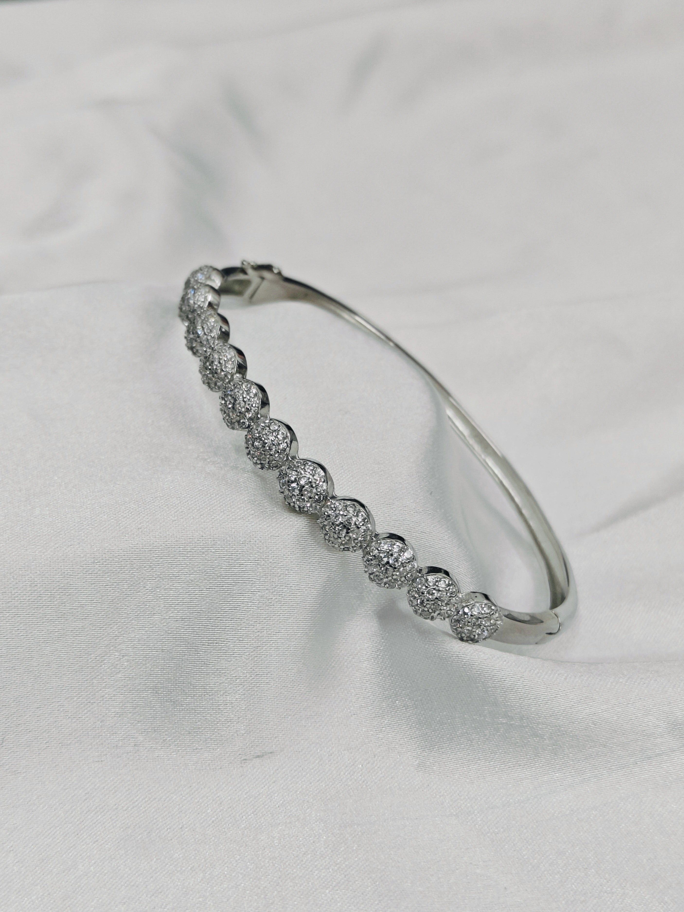 Silver bracelet with clear stones on a white fabric background